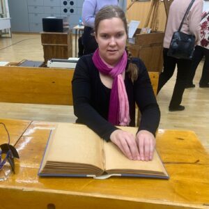 Woman reading an old braille book