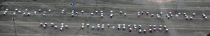 For the picture, people grouped themselves to form the lettering "Louis Braille Festival of the Encounter" with white umbrellas in braille.